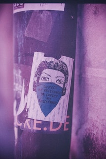 sticker on a streetlight pole with text that says "respect my existence or expect my resistance"