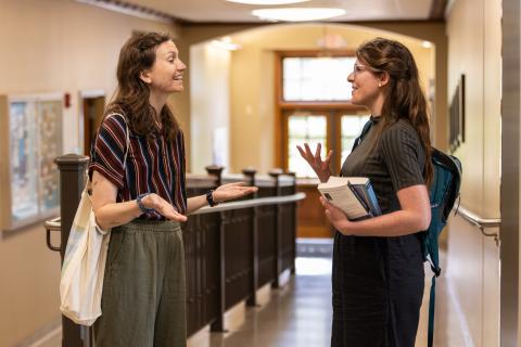 Two students talking in a hallway